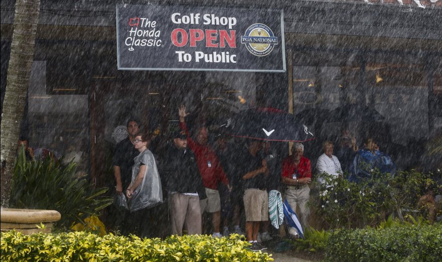 PALM BEACH GARDENS, FL - FEBRUARY 28:  Fans seek shelter just before the third round of The Honda Classic is suspended for the day at PGA National Resort & Spa - Champion Course on February 28, 2015 in Palm Beach Gardens, Florida.  (Photo by Sam Greenwood/Getty Images)