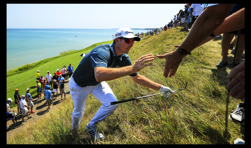 SHEBOYGAN, WI - AUGUST 14: Justin Rose of England is helped up a hill after playing his third shot on the 2nd hole during the second round of the 2015 PGA Championship at Whistling Straits on August 14, 2015 in Sheboygan, Wisconsin.  (Photo by David Cannon/Getty Images)