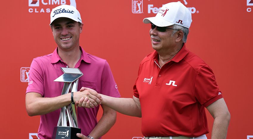 Justin Thomas receives the CIMB trophy for the second time